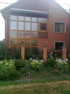 艾蓋爾紹洛克的住宿－Brigitta vendégház，前面有围栏和鲜花的房子