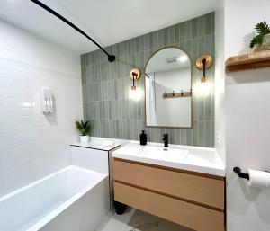 a bathroom with a sink and a tub and a mirror at MTLVacationRentals - The City Chalet in Montréal +26 photos