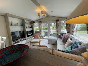 a living room with a couch and a television at Seton Sands Caravan Near Edinburgh & North Berwick in Port Seton