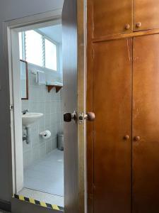 uma porta para uma casa de banho com um lavatório e um espelho em Hotel Armenia Centro em Armênia