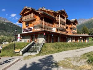 a large wooden building on a hill in the mountains at Appartement Lanslebourg-Mont-Cenis, 3 pièces, 6 personnes - FR-1-508-300 in Lanslebourg-Mont-Cenis