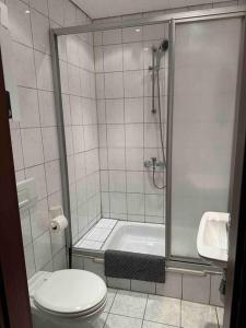 La salle de bains est pourvue d'une douche, de toilettes et d'un lavabo. dans l'établissement Monteurwohnung für bis zu 8 Personen in Essen, à Essen