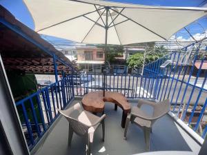 a balcony with a table and chairs and an umbrella at Puntarenas, Apartamento Mateo in Puntarenas