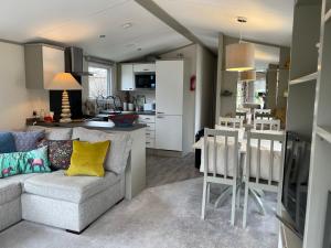 a living room with a couch and a kitchen at Seton Sands Caravan Near Edinburgh & North Berwick in Port Seton