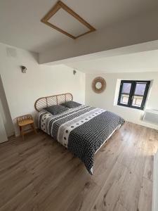 ein Schlafzimmer mit einem Bett mit einer schwarzen und weißen Decke in der Unterkunft La Maison du Roi Arthur in Carcassonne