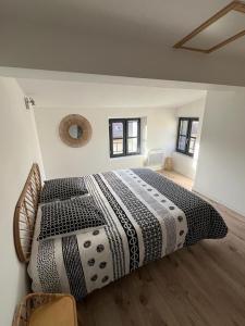 een slaapkamer met een groot bed en een zwart-wit dekbed bij La Maison du Roi Arthur in Carcassonne