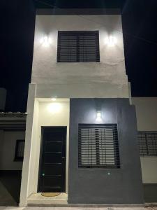 a white house with two windows and a door at Departamento Nº 6 en complejo semiprivado (2 habitaciones) in San Martín