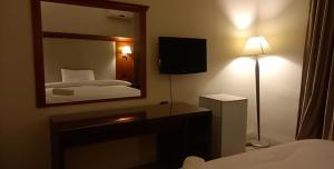 P.A.S.H.A BOUTIQUE HOTEL في عمّان: غرفة الفندق بسرير ومرآة