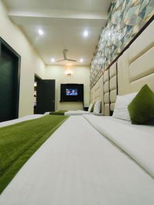 a bedroom with a large bed with a tv in it at Hotel Spiritual Land in Mathura
