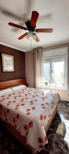a bedroom with a bed with red flowers on it at Apartamento 1 línea de playa + Parking! Salou in Salou