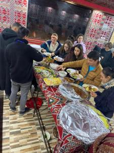 a group of people sitting at a table eating food at Wadi Rum albasli in Wadi Rum