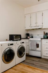 uma cozinha com armários brancos e uma máquina de lavar e secar roupa em Le Milton Open Concept Natural Sunlight Backyard em Montreal