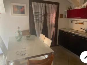 a kitchen with a white table and a counter top at Stupendo appartamento in Mozzo