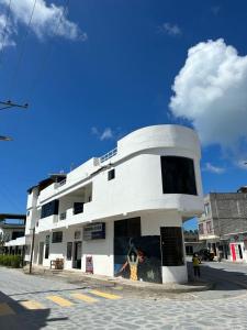 um edifício branco na esquina de uma rua em Hotel Isla del descanso em Puerto Villamil