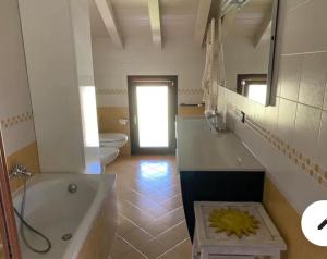 uma casa de banho com uma banheira, um WC e um lavatório. em Stupendo appartamento em Mozzo