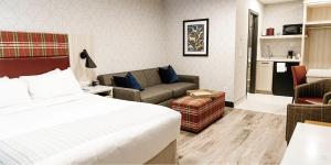 une chambre d'hôtel avec un lit et un canapé dans l'établissement Mountaineer Lodge, à Lake Louise