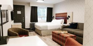 um quarto de hotel com uma cama e um sofá em Mountaineer Lodge em Lake Louise