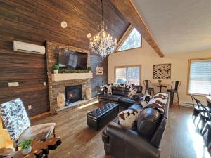 a living room with leather furniture and a fireplace at Swept Away Chalet - Luxurious NEW 6 BR Home Sleeps 16 Hot Tub Linens and Towels in Albrightsville