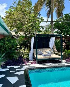 a bed sitting next to a swimming pool at THUISHAVEN boutique mini-resort - fantastic garden and large pool - adults only in Willemstad
