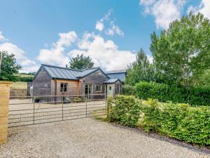 a wooden house with a fence in front of it at 2 Bed in Winchcombe 57828 in Winchcombe