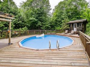 a swimming pool on a wooden deck with a woodenvisor around it at Meadowcreek Cottage in Utterson