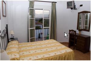 1 dormitorio con cama y ventana grande en Hostal Adrian en Pizarra