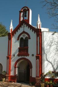 une église avec une tour et une porte en face de celle-ci dans l'établissement Hostal Adrian, à Pizarra