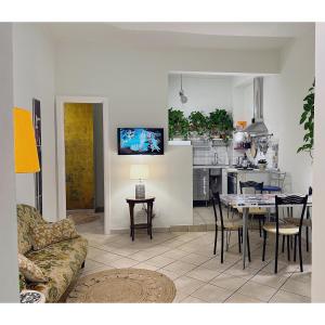 ein Wohnzimmer und eine Küche mit einem Tisch und einer Couch in der Unterkunft Leda's Home in Rom + 37 Fotos