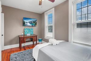 1 dormitorio con cama, mesa y ventanas en The Schumacher Cottage- 2 BR w Parking & Yard, en Columbus