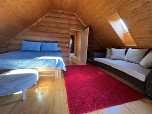 a bedroom with two beds and a red rug at Zrub Hanesy in Donovaly