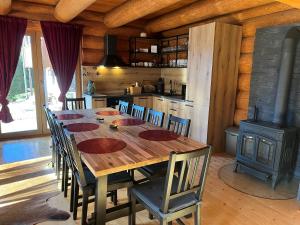 a dining room with a wooden table and a stove at Zrub Hanesy in Donovaly