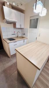 a kitchen with white cabinets and a wooden counter top at Studio Gdańsk Śródmieście in Gdańsk