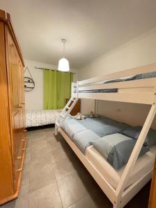 1 Schlafzimmer mit 2 Etagenbetten und einem grünen Fenster in der Unterkunft UIM Mediterraneo PB Miguel Hernandez Wifi in Puerto de Sagunto