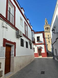 una calle con un edificio con una torre de reloj en el fondo en Ocón 2, en Lebrija