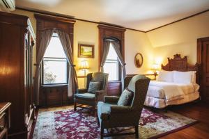 a hotel room with a bed and two chairs at Cedar Crest Inn in Asheville