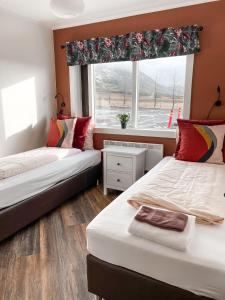 two beds in a room with a window at Setberg Guesthouse in Nesjum
