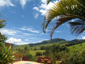vista sulle colline da un giardino con palma di Pousada Refugio Sol e Brisa a São Bento do Sapucaí