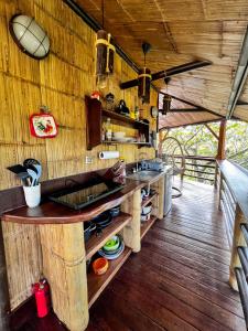 Il comprend une cuisine avec des murs en bois et du parquet. dans l'établissement TREEHOUSE PILON PAVONES, à Pavones