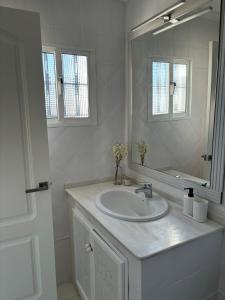 a white bathroom with a sink and a mirror at Ocón 2 in Lebrija