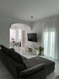 Sala de estar blanca con sofá y mesa en Ocón 2, en Lebrija