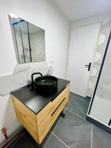 a bathroom with a black sink and a mirror at Appartement Nicolas in Aujac +7 photos