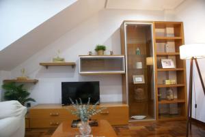 a living room with a couch and a tv at El Capricho de Candás in Candás