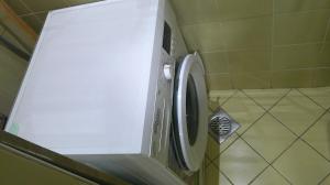 a white washing machine in a corner of a bathroom at Ruby Star Couples Hostel G P 1&2 in Dubai