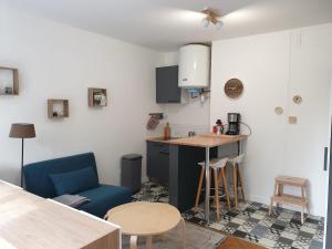 eine Küche mit einem blauen Sofa und einem Tisch in der Unterkunft Meublé très cosy à proximité de toutes commodités in Rouen