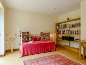 um quarto com uma cama com lençóis vermelhos e uma estante de livros em 1 Bed in Nantyglo 58304 em Nantyglo