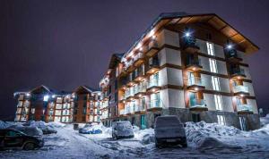 a large building with cars parked in the snow at New Gudauri Loft2 #433 in Gudauri