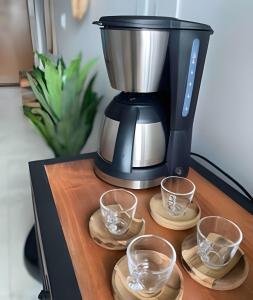 eine schwarze Kaffeemaschine auf einem Tisch mit Brille in der Unterkunft Porto Galinhas no Centro e nas Piscinas Naturais in Porto De Galinhas