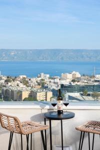 una mesa con 2 copas de vino en el balcón en מצפה כנרת טבריה, en Tiberíades