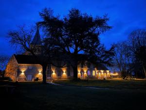 a house with a tree in front of it at night at Le SAN - Chambre d'hôtes INCLUSIVE & ÉCORESPONSABLE in Beauchery