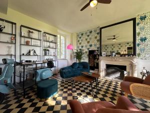 a living room with blue chairs and a fireplace at Le SAN - Chambre d'hôtes INCLUSIVE & ÉCORESPONSABLE in Beauchery